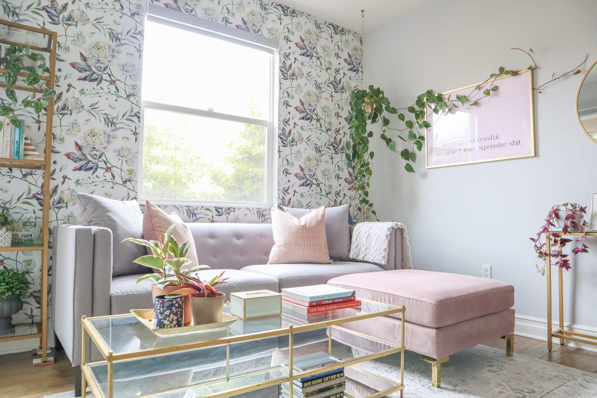 blush and grey office decor with floral wallpaper accent wall, gold and glass coffee table and a hanging plant